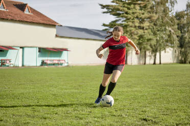 Mädchen spielt mit Fußball auf einem Feld - ZEDF04901