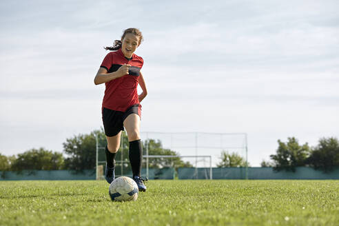 Fußballspieler mit Ball auf einem Sportplatz - ZEDF04903