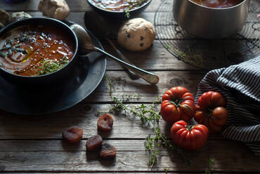 Zusammensetzung der servierten Schalen mit köstlichen Tomatencremesuppe mit Samen auf dem Tisch mit Tomaten und Brot Brötchen - ADSF39553