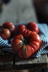 Von oben reife rote Tomaten mit gestreifter Serviette auf Holztisch - ADSF39556