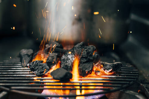 Closeup of blazing burning coal in flame and sparkles on grill - ADSF39579