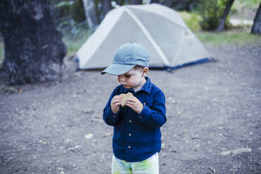 Süßer Junge mit Mütze isst Smore vor einem Zelt - ACTF00261