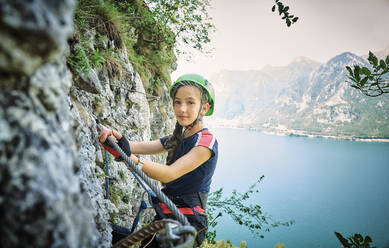 Mädchen beim Bergsteigen mit dem Idrosee im Hintergrund - DIKF00739