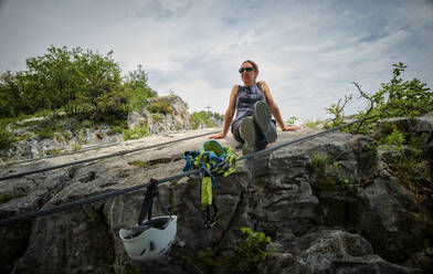Reife Frau entspannt sich auf einem Felsen - DIKF00750