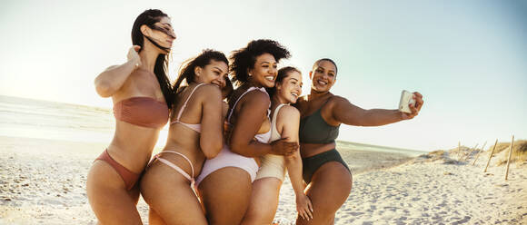 Group of young women dancing together in bikinis. Happy young
