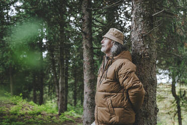 Contemplative man standing by tree in forest - YTF00235