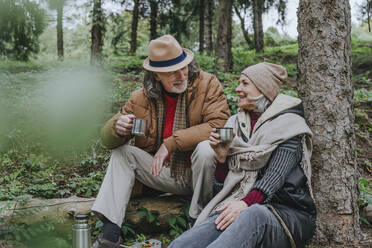 Glückliches Paar genießt heißen Tee im Wald - YTF00267