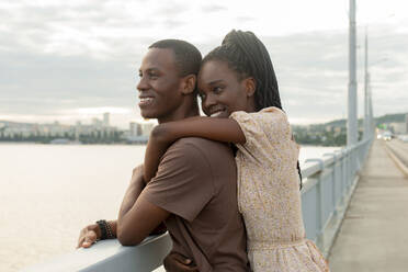 Kontemplatives junges Paar auf einer Brücke stehend - JBUF00026