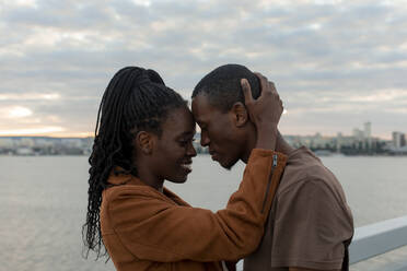 Romantic couple head to head by railing in front of river
 - JBUF00035