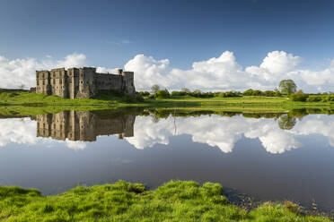 Die herrlichen Ruinen von Carew Castle spiegeln sich im Frühling im Mühlenteich, Carew, Pembrokeshire, Wales, Vereinigtes Königreich, Europa - RHPLF23321