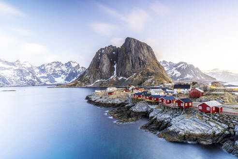 Hochformatige Ansicht der traditionellen roten Rorbu-Hütten im Fischerdorf Hamnoy in der Morgendämmerung, Reine, Lofoten, Norwegen, Europa - RHPLF23347