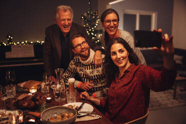 Frau nimmt Selfie mit Familie während Thanksgiving-Dinner. Europäische Familie nimmt Selfies am Heiligabend. - JLPSF10896