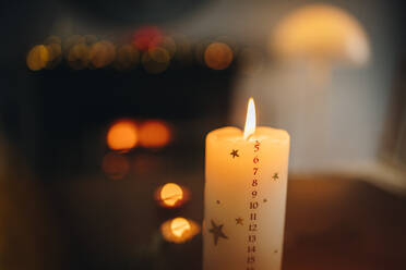 Close-up of a burning christmas candle. Countdown to Christmas on burning candle with december month date numbers. - JLPSF10919