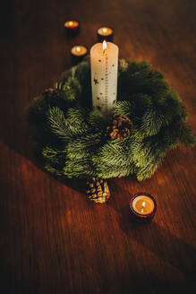 Adventskranz mit brennenden Kerzen auf dem Tisch. Schöne Weihnachtsdekoration zu Hause. - JLPSF10923