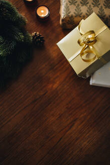 Weihnachtsgeschenke mit Adventskranz und Kerzen auf hölzernem Hintergrund. Weihnachtsdekoration auf einem Tisch. - JLPSF10925