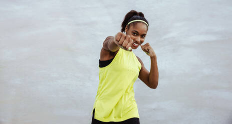 Woman doing boxing workout against white background. Fitness female doing shadow boxing exercise. - JLPSF11013