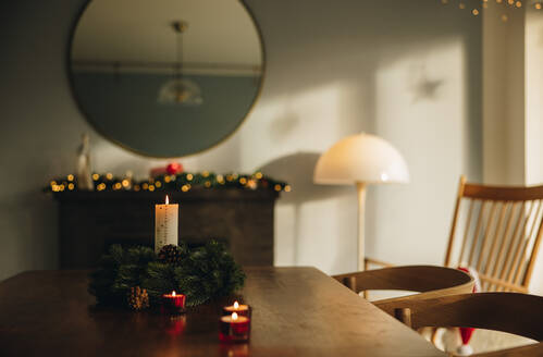 Skandinavisches Haus, dekoriert für die Weihnachtsfeier. Adventskerze auf dem Tisch mit Kranz. - JLPSF11127