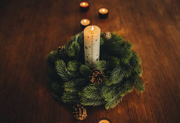 Top view of Christmas holiday decorations on wooden table. Advent wreath with burning candles. - JLPSF11148