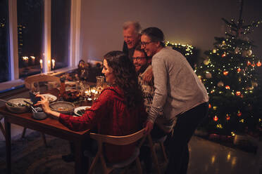 Online-Weihnachtsessen mit der Familie. Frau mit Handy in der Hand, die während einer Pandemie einen Videoanruf mit einem geliebten Menschen führt. - JLPSF11167