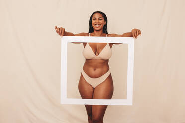 Diverse young women wear underwear sitting showing legs on beige  background. Stock Photo by insta_photos