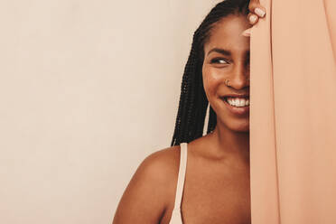 Unshaven young woman smiling cheerfully while wearing a bra and jeans.  Happy young woman embracing her natural body and underarm hair. Body  positive young woman making her own choice about her body.