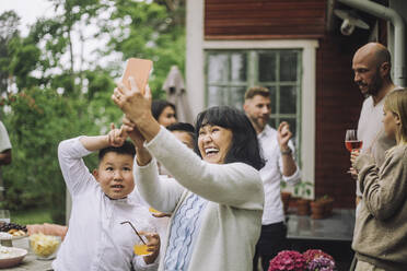 Glückliche Großmutter nimmt Selfie durch Smartphone mit Enkelkindern auf Party - MASF32216