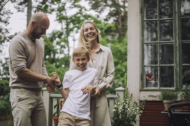 Father and mother playing with happy son while in backyard - MASF32248