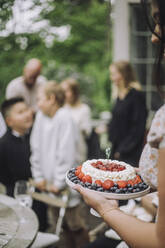 Frau hält frischen Obstkuchen bei einer Geburtstagsfeier - MASF32268