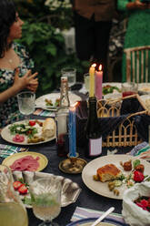 Essen und Getränke mit beleuchteten Kerzen am Tisch während der Party - MASF32306