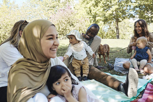 Männliche und weibliche Freunde mit Kindern, die sich im Park vergnügen - MASF32362