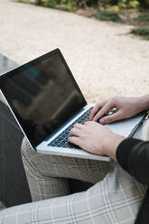 Hands of student using laptop on wall - EGAF02582