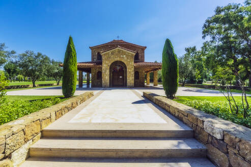 Griechenland, Zentralmazedonien, Chalkidiki, Fassade einer kleinen Steinkirche mit Zypressen im Vordergrund - THAF03097