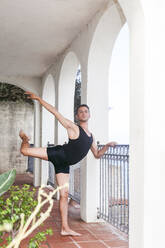 Male dancer practicing by railing on porch - ACTF00282