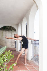 Dancer practicing by railing on porch - ACTF00283