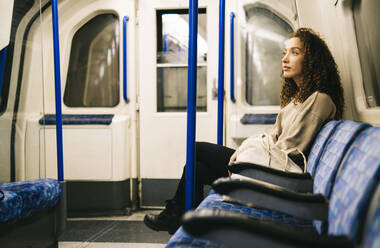 Kontemplative Frau in der U-Bahn sitzend - AMWF00889