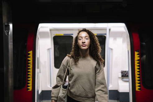 Young woman disembarking from train at subway station - AMWF00926