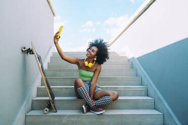 Young woman taking selfie through smart phone on steps - OIPF02445