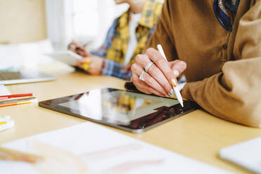 Graphic designer with digitized pen using tablet PC at desk - MDOF00052