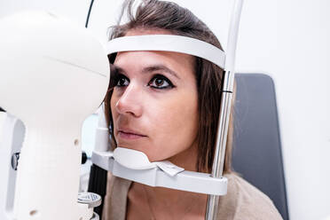 Arzt mit modernem Tonometer zur Bestimmung des Augeninnendrucks einer Frau bei der Arbeit in der Augenklinik - ADSF39634