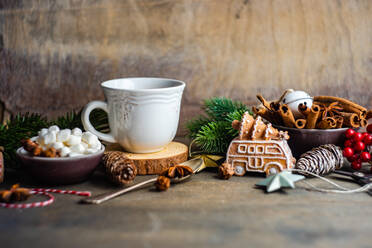 Mug with hot drink and mini marshmallows with spices on background with christmas decorations - ADSF39662