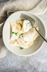 From above traditional ukrainian dumplings stuffed with potato, well-known vareniki, served in a bowl with sour cream - ADSF39796