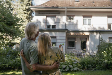 Couple standing together looking at house - RIBF01096