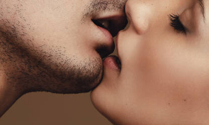 Close up of young man and woman kissing. Close up of a romantic young couple kissing with eyes closed. - JLPSF11390