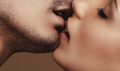 Nahaufnahme eines jungen Mannes und einer Frau, die sich küssen. Nahaufnahme eines romantischen jungen Paares, das sich mit geschlossenen Augen küsst. - JLPSF11390