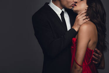 Young couple lost in love, kissing over grey background. Sensual man and woman kissing each other with love. - JLPSF11424