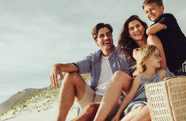 Schönes Paar mit Sohn und Tochter, die sich an einem Sommertag am Meer entspannen. Glückliche Familie am Strand. - JLPSF11469