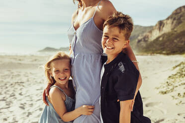 Junge und Mädchen mit ihrer Mutter am Strand. Kinder stehen mit ihrer Mutter an einem Sommertag am Meer. - JLPSF11470