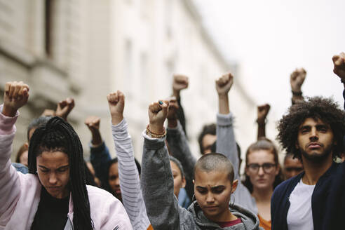 Gruppe von Demonstranten auf der Straße mit erhobenen Armen. Multiethnische Menschen protestieren auf der Straße. - JLPSF11480