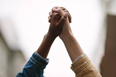 Two women activists holding hands. Demonstrators protesting together holding hands. - JLPSF11502