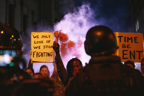 Gruppe von Aktivisten, die nachts mit Rauchgranaten protestieren. Gruppe von Männern und Frauen bei einem Protest gegen die Regierung. - JLPSF11557